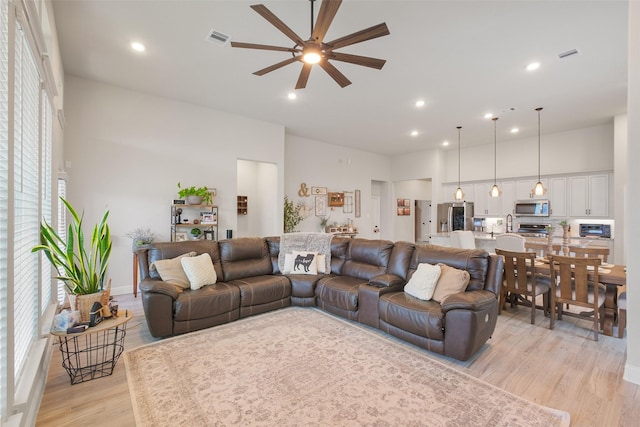 living room with light hardwood / wood-style flooring and ceiling fan