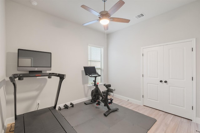 workout room with ceiling fan and light hardwood / wood-style floors