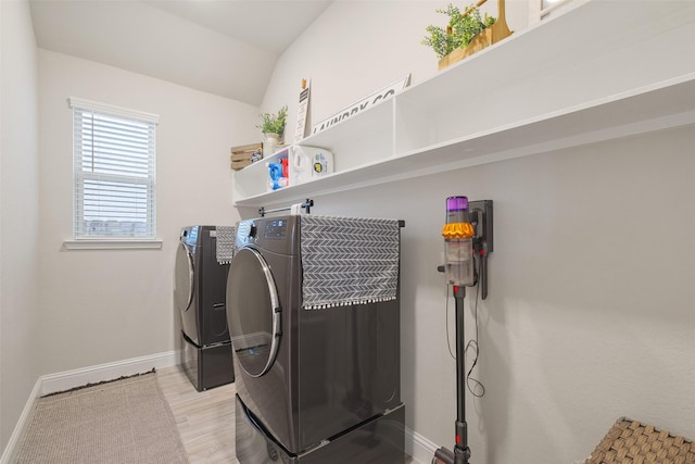 laundry area with washer and clothes dryer and light wood-type flooring