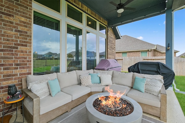 view of patio with ceiling fan and an outdoor living space with a fire pit