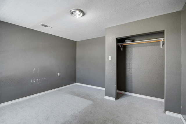 unfurnished bedroom featuring a closet, carpet floors, and a textured ceiling