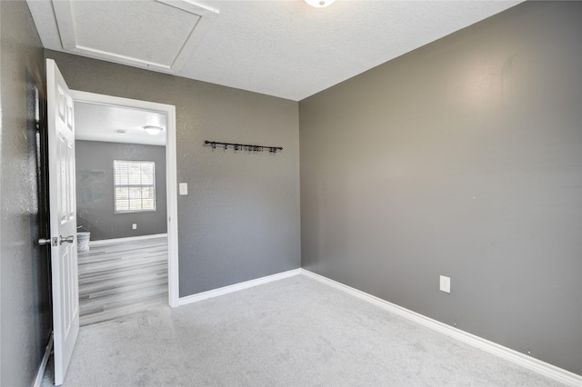 carpeted empty room featuring a textured ceiling