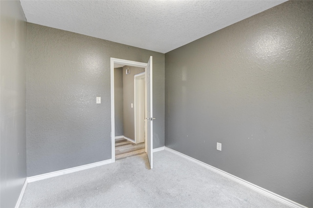 unfurnished bedroom with a textured ceiling and light carpet