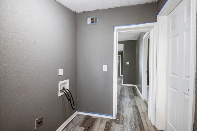 laundry room featuring hookup for a washing machine, hardwood / wood-style floors, and a textured ceiling