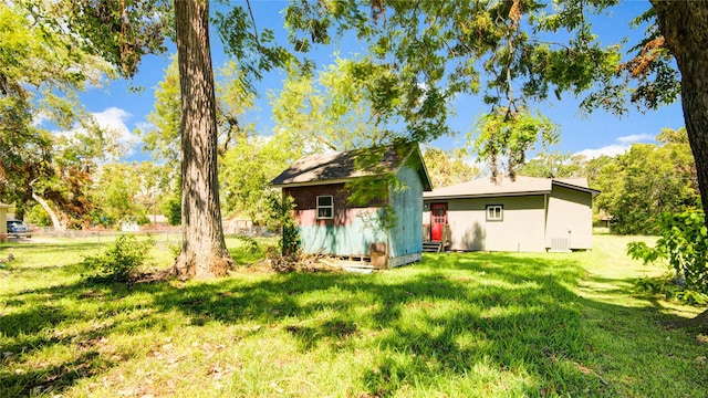 rear view of property featuring a storage unit and a lawn