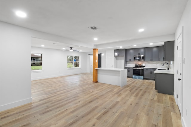 kitchen featuring gray cabinetry, ceiling fan, sink, stainless steel appliances, and tasteful backsplash