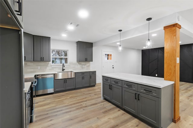 kitchen with gray cabinetry, decorative backsplash, dishwasher, and sink