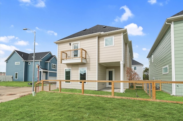 back of house featuring a balcony and a lawn