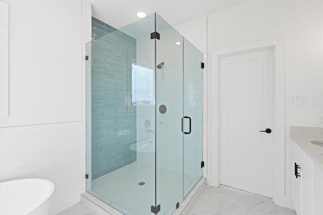 bathroom featuring shower with separate bathtub and vanity