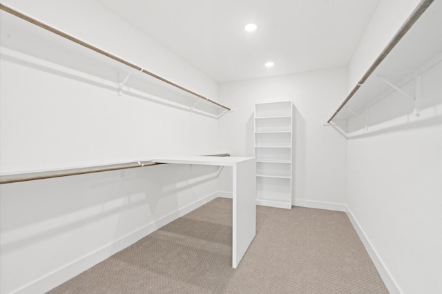 walk in closet featuring light colored carpet