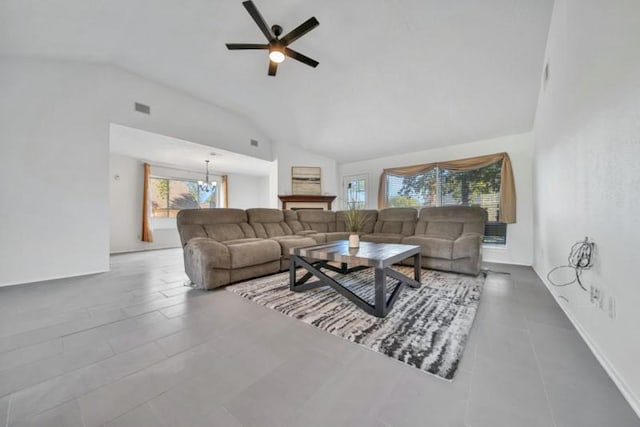 living room with ceiling fan with notable chandelier and high vaulted ceiling