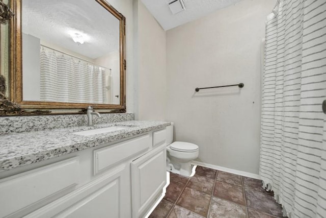 bathroom with vanity, a textured ceiling, and toilet