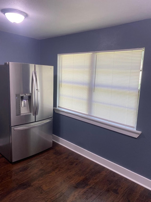 kitchen with dark hardwood / wood-style flooring and stainless steel refrigerator with ice dispenser