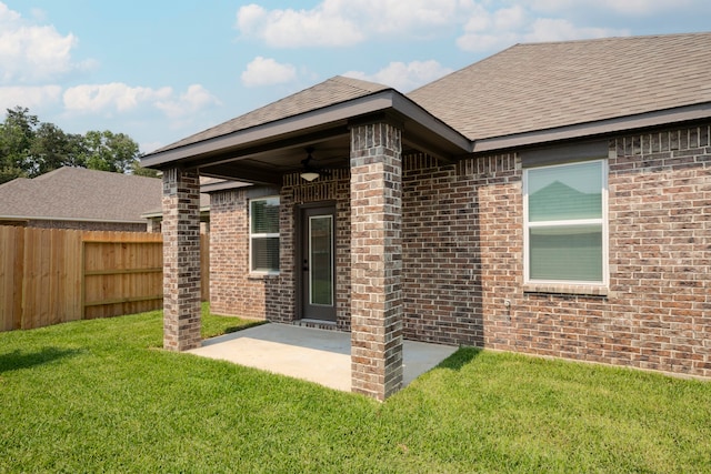 back of house featuring ceiling fan, a patio area, and a yard