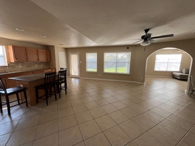 tiled dining room featuring a textured ceiling and ceiling fan