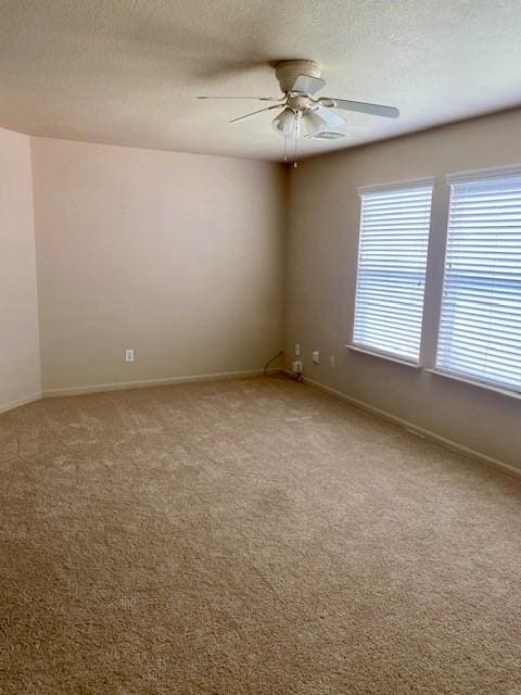 unfurnished room featuring ceiling fan, carpet, and a textured ceiling