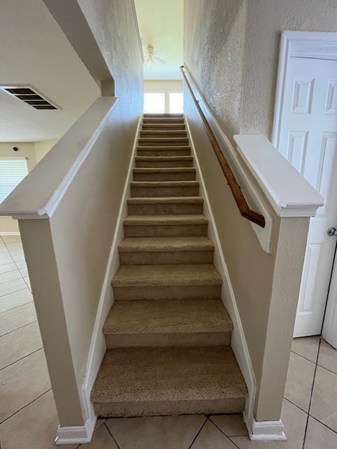 stairs with tile patterned flooring and ceiling fan