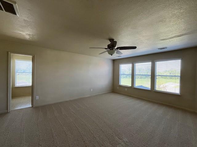 unfurnished room featuring carpet, a textured ceiling, and ceiling fan