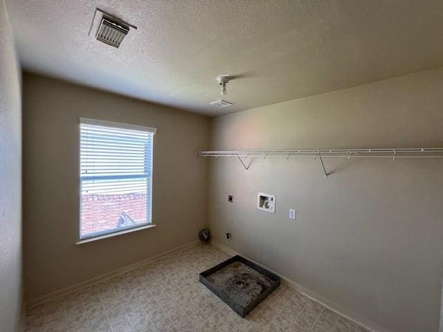 laundry area with washer hookup, a textured ceiling, gas dryer hookup, and electric dryer hookup