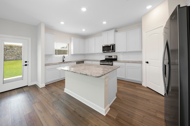 kitchen featuring sink, a kitchen island, dark hardwood / wood-style floors, white cabinets, and appliances with stainless steel finishes