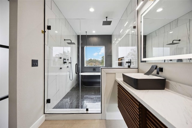 bathroom featuring plus walk in shower, vanity, and tile patterned floors