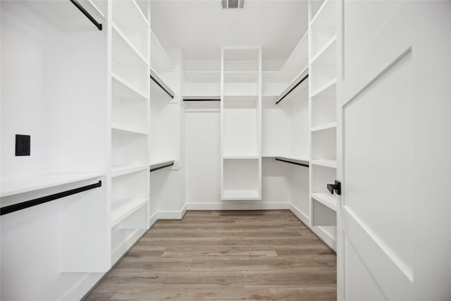 spacious closet featuring light hardwood / wood-style flooring