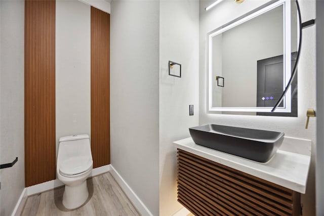 bathroom featuring hardwood / wood-style flooring, vanity, and toilet