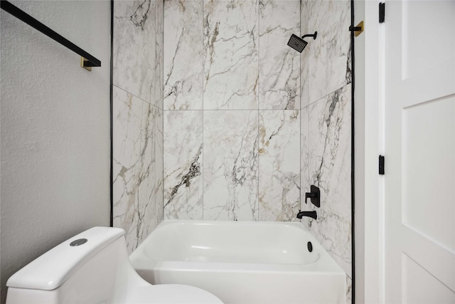 bathroom with tiled shower / bath combo and toilet