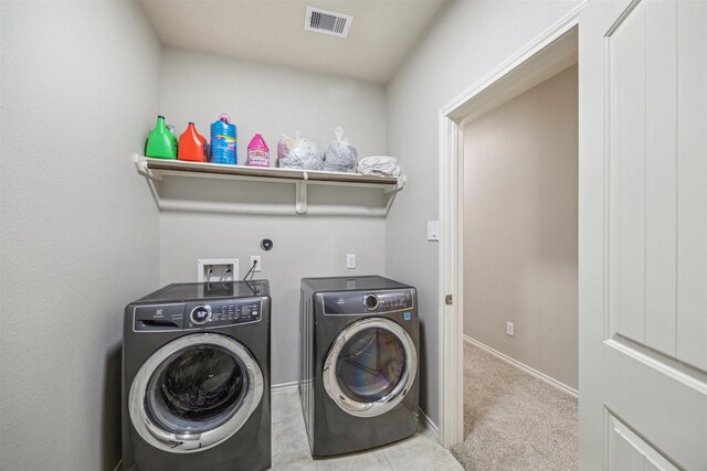 clothes washing area featuring separate washer and dryer and light colored carpet