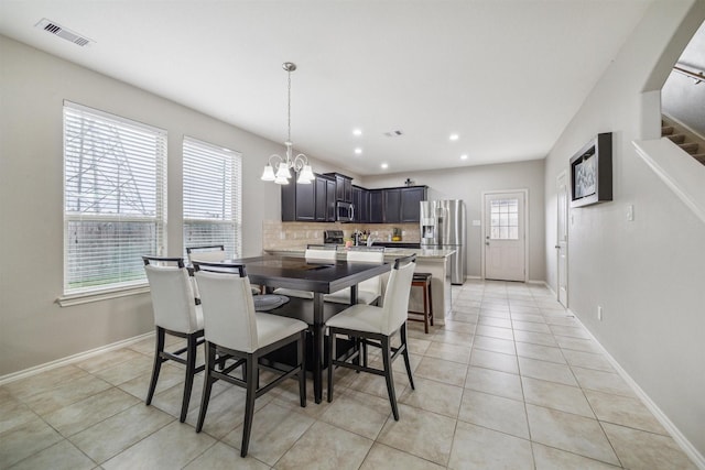 dining room with plenty of natural light, light tile patterned floors, and a notable chandelier