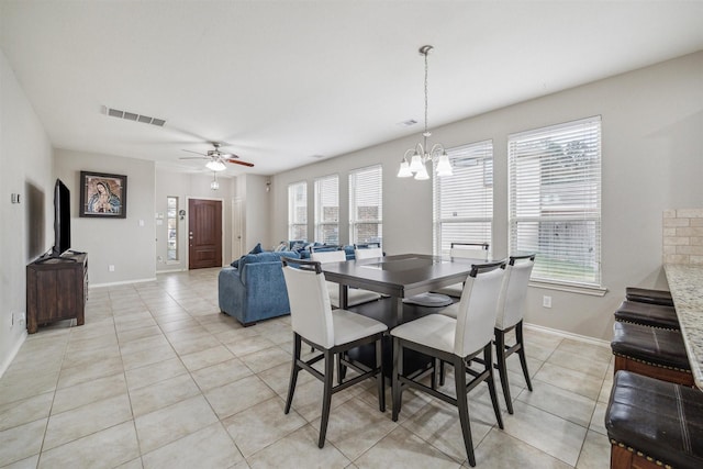 dining room featuring plenty of natural light, light tile patterned floors, and ceiling fan with notable chandelier