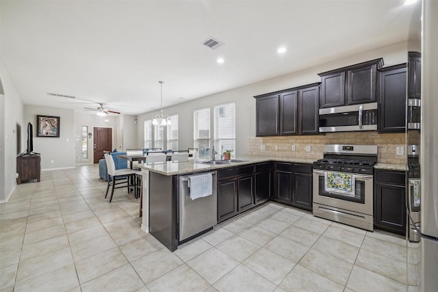 kitchen with decorative light fixtures, ceiling fan with notable chandelier, stainless steel appliances, and light tile patterned floors