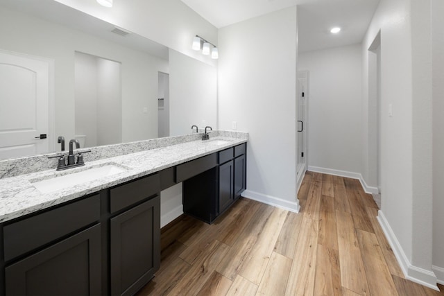 bathroom featuring hardwood / wood-style floors, vanity, and an enclosed shower