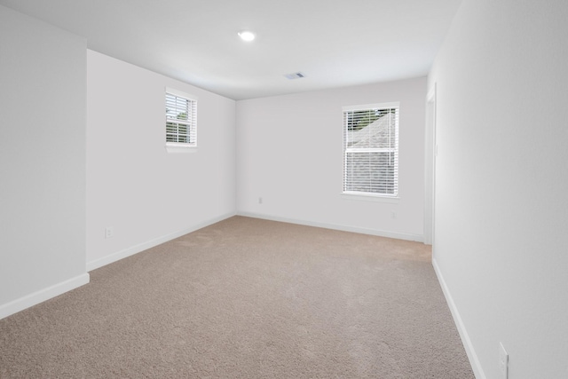 unfurnished room featuring light carpet