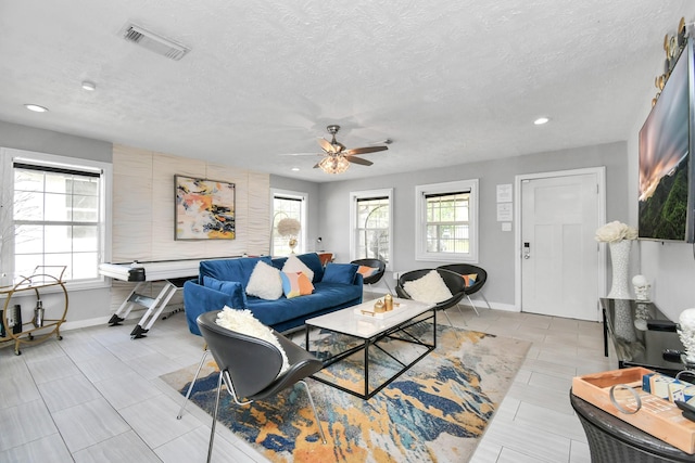 living room featuring a textured ceiling and ceiling fan