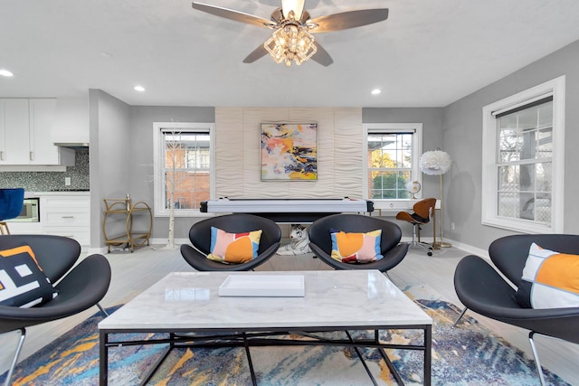 living room featuring ceiling fan and light hardwood / wood-style floors