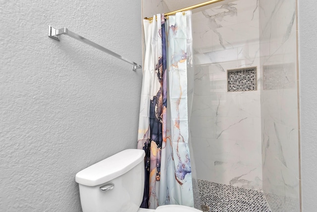 bathroom with toilet and a shower with shower curtain