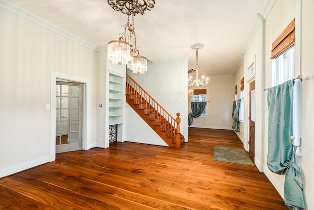 foyer with crown molding, an inviting chandelier, and hardwood / wood-style floors