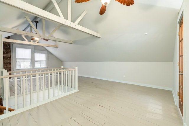 additional living space with lofted ceiling with beams and wood-type flooring