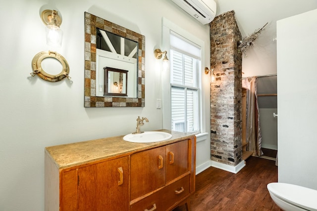 bathroom with an AC wall unit, curtained shower, wood-type flooring, vanity, and toilet