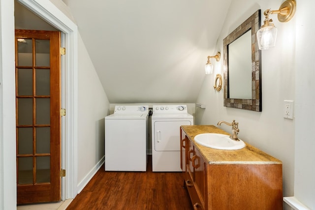 washroom with washing machine and dryer, sink, and dark wood-type flooring