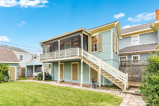 rear view of property featuring a sunroom and a yard