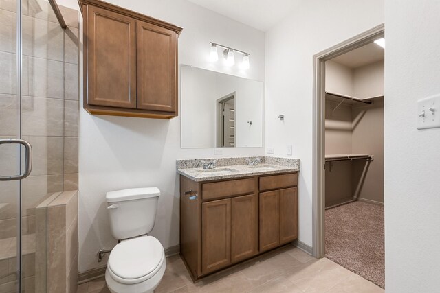 bathroom featuring vanity, tile patterned floors, a shower with shower door, and toilet