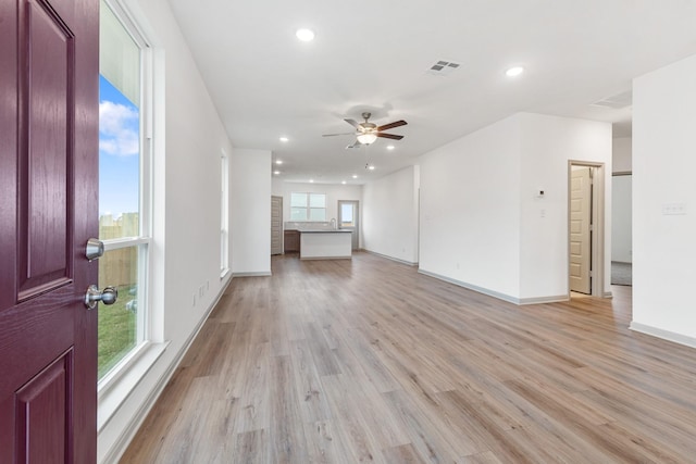 unfurnished living room featuring ceiling fan, light hardwood / wood-style flooring, and plenty of natural light