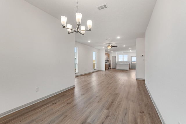 unfurnished living room featuring hardwood / wood-style floors and ceiling fan with notable chandelier