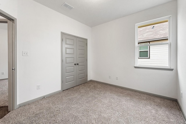 unfurnished bedroom featuring a closet and carpet flooring