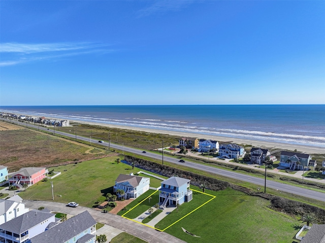 drone / aerial view featuring a water view, a residential view, and a view of the beach