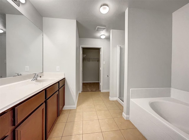 bathroom with tile patterned floors, vanity, a textured ceiling, and independent shower and bath