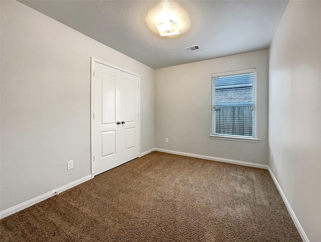 unfurnished bedroom featuring carpet floors and a textured ceiling