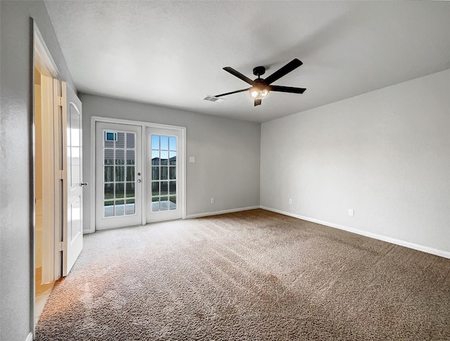 empty room with ceiling fan, light colored carpet, and french doors